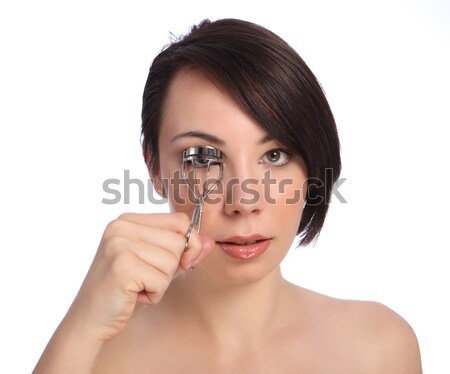 Beautiful young woman using eye lash curler Stock photo © darrinhenry