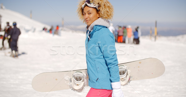 Trendy young woman carrying her snowboard Stock photo © dash