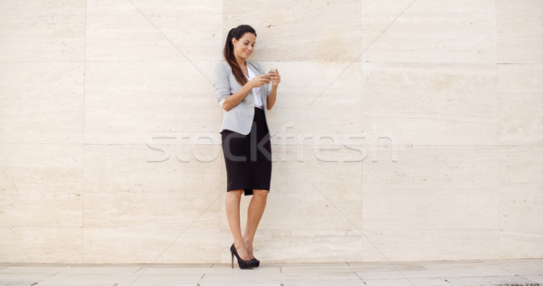Pretty young woman checking her mobile phone Stock photo © dash