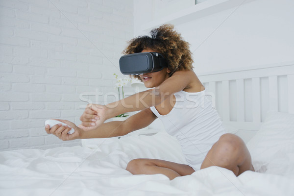 Excited woman gaming in VR glasses Stock photo © dash