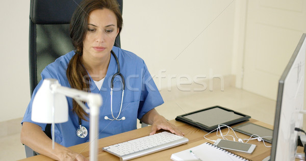 Stock photo: Doctor working at her desk in the office