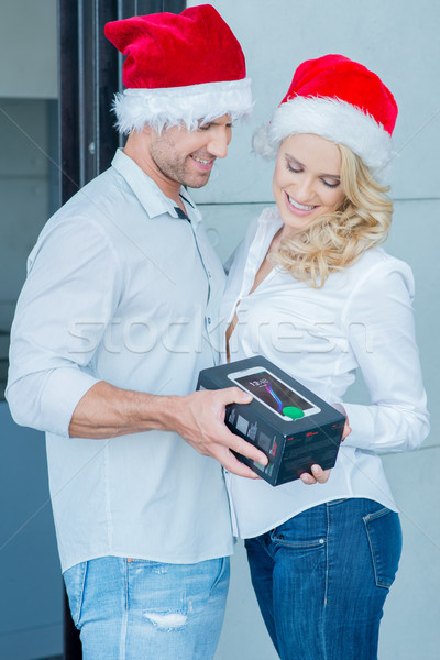 Couple Wearing Santa Hats Exchanging Gift Stock photo © dash