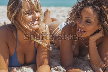 Diverse girl chatting on sandy shoreline Stock photo © dash