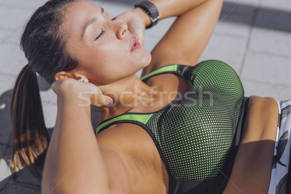 Woman exercising abs on pavement Stock photo © dash