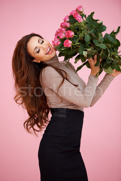 Happy vivacious woman with pink roses Stock photo © dash
