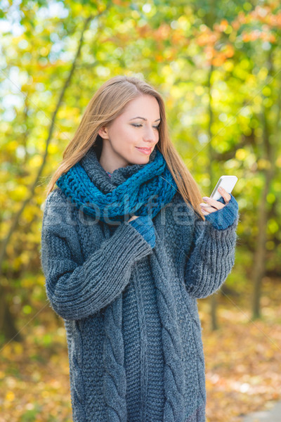 Young woman using a mobile outdoors in autumn Stock photo © dash