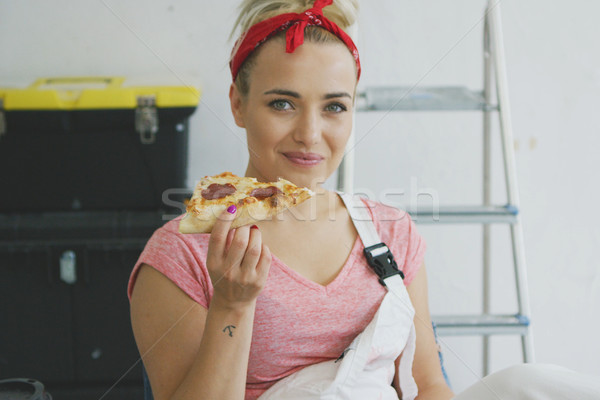 Smiling woman in overalls eating tasty pizza Stock photo © dash