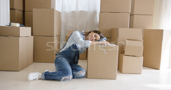 Tired young woman taking a break from packing Stock photo © dash