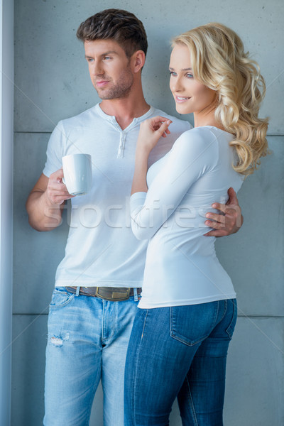 Attractive couple standing looking out of a window Stock photo © dash