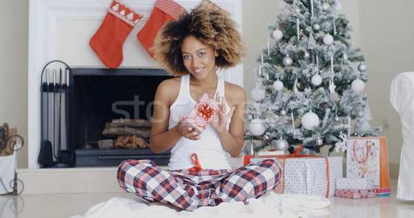 Stock photo: Pretty smiling woman displaying a Christmas gift