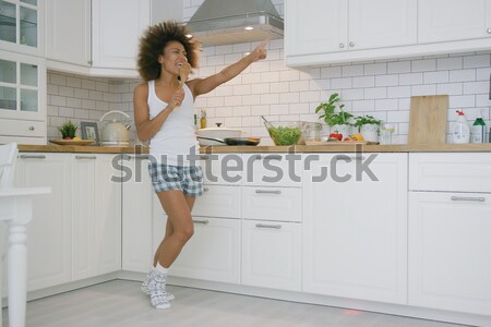 Woman in VR glasses dancing in kitchen Stock photo © dash