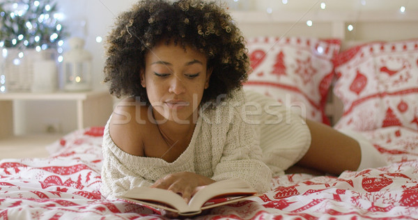 Calm beautiful African woman reading in bed Stock photo © dash