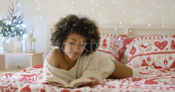 Calm beautiful African woman reading in bed Stock photo © dash