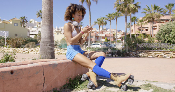 Female wearing rollerskates sitting on curb Stock photo © dash