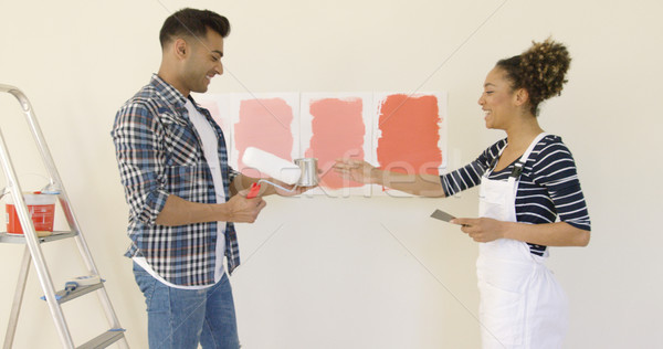 Laughing young couple choosing a paint color Stock photo © dash