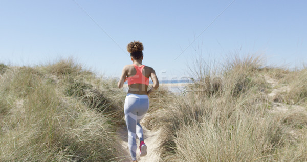 Femeie jogging plajă vedere din spate cardio Imagine de stoc © dash