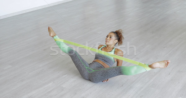 Woman stretching legs with band Stock photo © dash