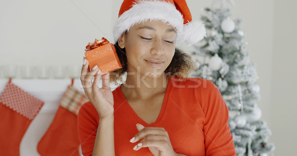 Curious young woman shaking her Christmas gift Stock photo © dash