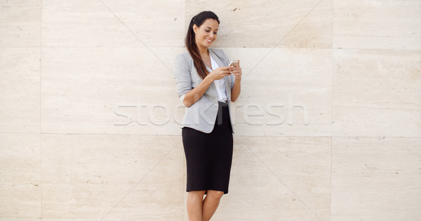 Pretty young woman checking her mobile phone Stock photo © dash
