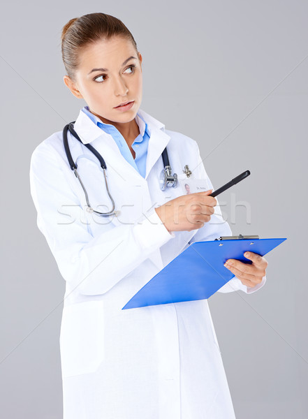 Mujer médico portapapeles pie senalando pluma Foto stock © dash