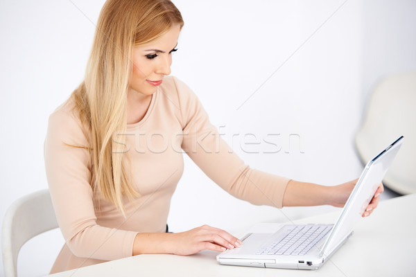 Stock photo: Attractive blond woman working on a laptop