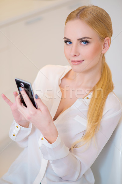 Pretty Blond Female with Phone Looking at Camera Stock photo © dash