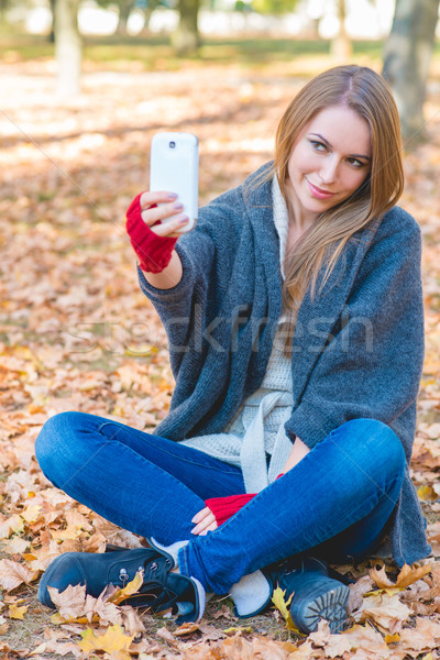 Smiling woman taking a selfie in an autumn park Stock photo © dash