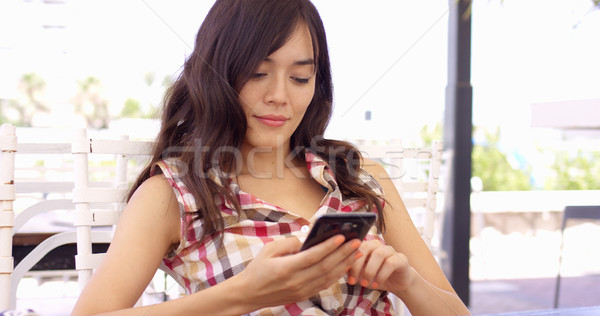Jeune femme détente patio mobiles extérieur téléphone portable [[stock_photo]] © dash