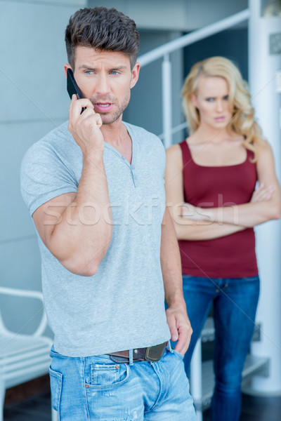 Man talking on his mobile watched by wife Stock photo © dash