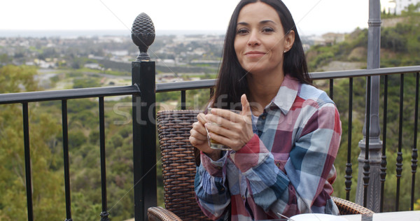 Smiling young woman relaxing outdoors with tea Stock photo © dash