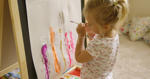 Little girl standing painting at an easel Stock photo © dash