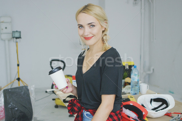 Smiling female with paper cup in workshop  Stock photo © dash