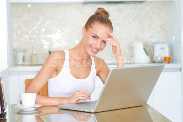 Smiling woman working on a laptop at home Stock photo © dash