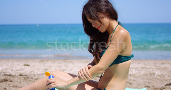 Young woman applying sun cream to her legs Stock photo © dash
