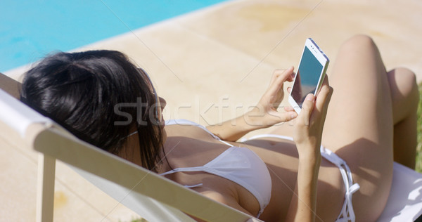 Young woman browsing on a mobile in the summer sun Stock photo © dash