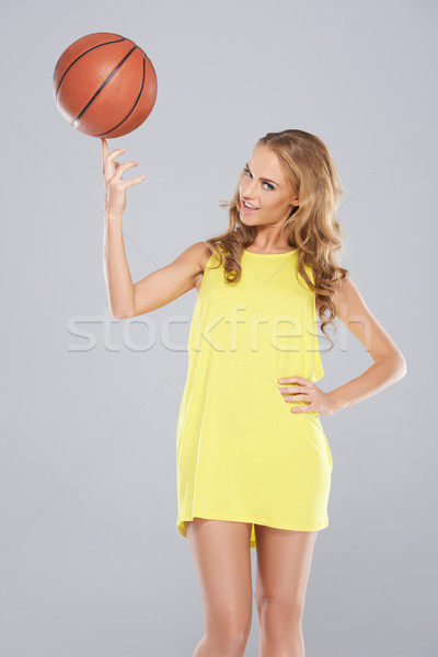 Cute woman posing and spin basket ball on her finger Stock photo © dash