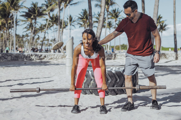 Man supporting girl with squats on beach Stock photo © dash