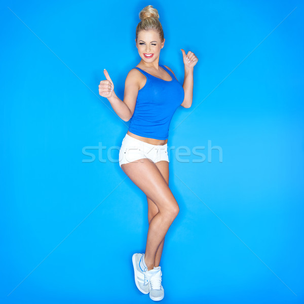Young Woman Squinting And  Showing Thumb Up Sign Stock photo © dash