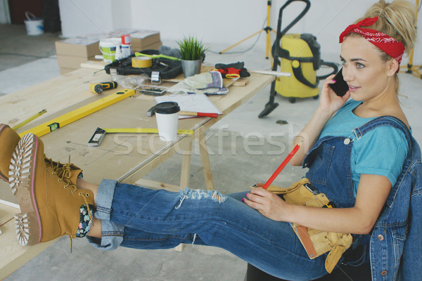 Stock photo: Female carpenter at workplace talking on smartphone 