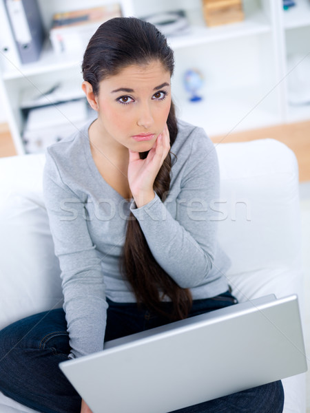 Lady sitting on sofa with concerned look Stock photo © dash