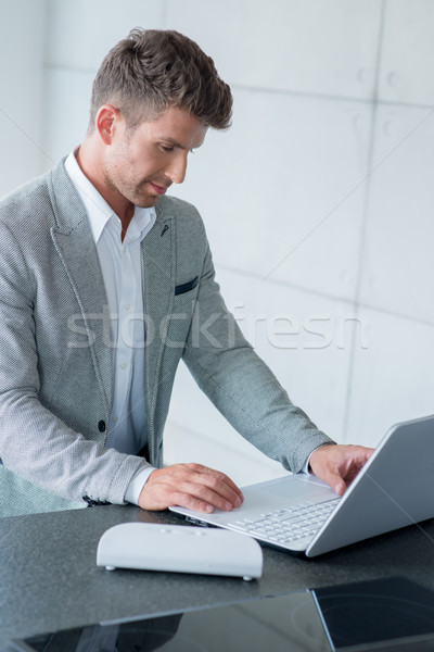 Stylish man sitting typing on a laptop Stock photo © dash