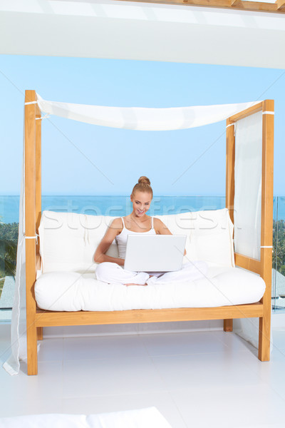 Stock photo: Woman on canopied seat with laptop