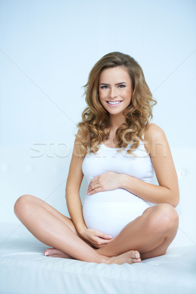 Heureux enceintes jeune femme canapé séance femme Photo stock © dash