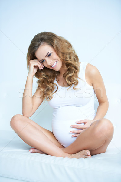 Ziemlich lächelnd schwanger Sitzung Bett lockig Stock foto © dash