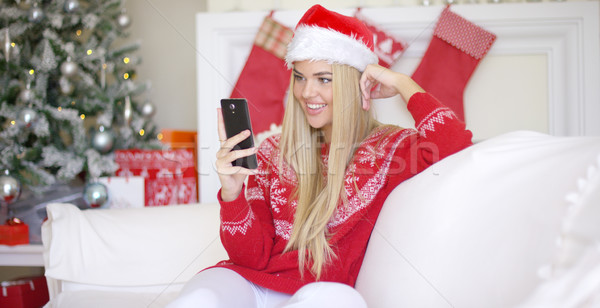 Young happy blond girl in Christmas outfit using mobile phone Stock photo © dash