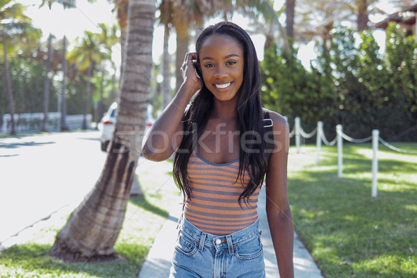 Smiling black woman adjusting hair Stock photo © dash