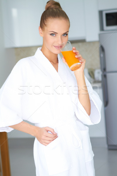 Woman in bath robe drinking orange juice Stock photo © dash