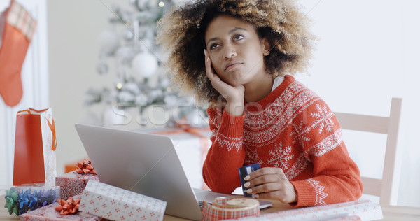 Young woman pondering over an online purchase Stock photo © dash