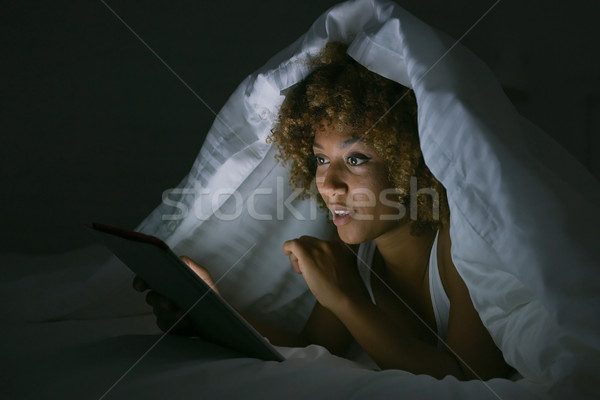Woman using tablet under blanket Stock photo © dash