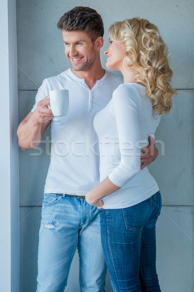 Affection couple standing looking out of a window Stock photo © dash